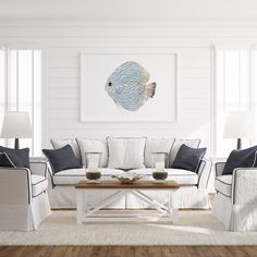 a living room with white furniture and blue accents