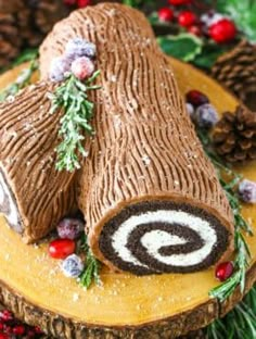 a log cake decorated with pine cones and berries