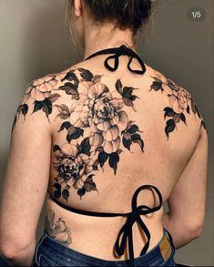 the back of a woman's top with flowers and scissors tattooed on her chest