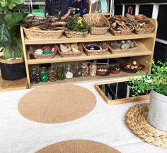 two people standing in front of a shelf filled with baskets and other items on display