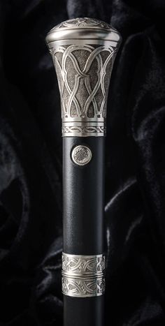 an ornate silver and black pen on a black background