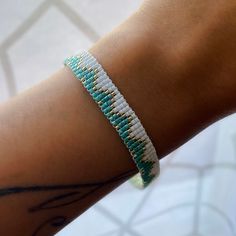 a close up of a person's arm wearing a bracelet with beads on it