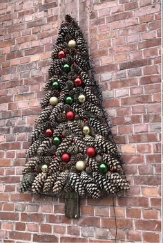 a christmas tree made out of pine cones on a brick wall