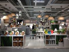 the inside of a store filled with lots of plants and food on display in front of people