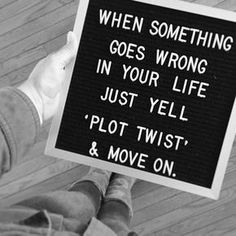 a person holding a sign that says when something goes wrong in your life just yell plot twist & move on