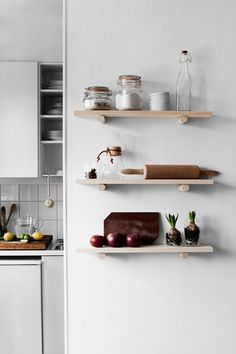 three wooden shelves on the wall in a kitchen