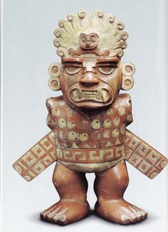 a wooden statue with an elaborate design on it's face and arms, standing in front of a white background