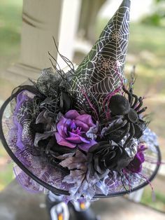 a purple and black hat with spider webs on it's side sitting on a porch