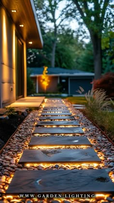 a walkway made out of stones and lit up with leds in the evening time