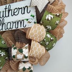 a wreath made with burlocks and ribbons is shown in front of a sign that says southern charm