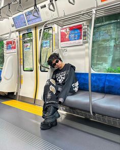 a man sitting on a subway train with his headphones in his ears and sunglasses on