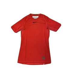 a red shirt that is sitting on a white surface with the word nike written on it