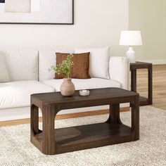 a living room with a white couch and coffee table in front of a painting on the wall