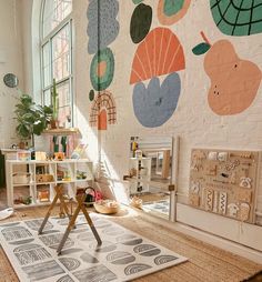 a child's playroom with various toys on the floor and large windows in the background