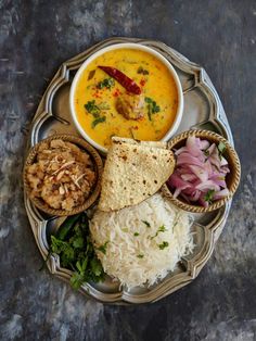 a plate with rice, bread and soup on it