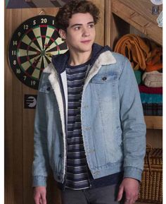 a young man standing in front of a dart board