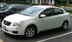 two white cars parked in a parking lot next to each other