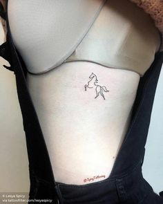 a woman's stomach with a small tattoo of a horse on her left side