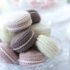 several crocheted donuts are in a glass bowl on a table with other items