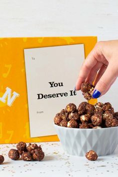 a person is scooping something out of a bowl with some peanuts in front of them