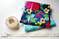 three pieces of fabric and a roll of tape on a white surface with a pair of scissors