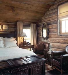 a rustic log cabin bedroom with white bedding and brown leather chairs in the corner