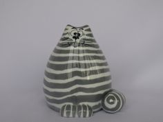 a gray and white cat figurine sitting on top of a table