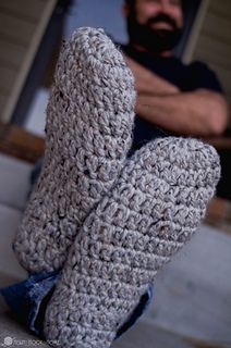 a close up of a person wearing crocheted slippers