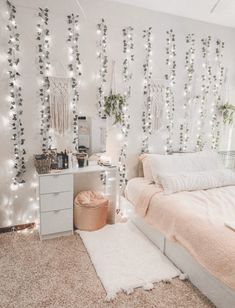 a bedroom with white lights on the wall and pink bedding in front of it