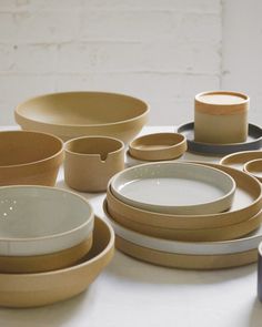 a table topped with lots of different types of plates and bowls next to each other