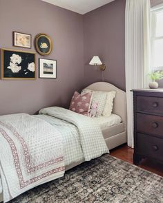 a bedroom with purple walls and pictures on the wall above it that says back to school sale two spaces