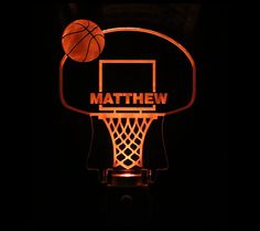 a basketball hoop with the word mathew on it is lit up in the dark