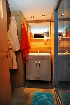 a bathroom with a sink and mirror next to a blue rug on the floor in front of it