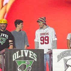 the men are standing on stage with their helmets on