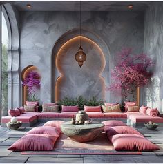 a living room filled with lots of pink couches and pillows on top of a stone floor