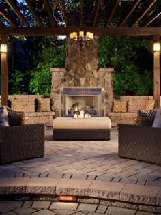 an outdoor living area with couches, chairs and a fire place in the middle