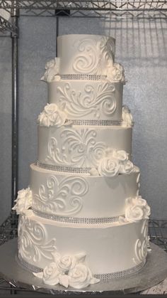 a white wedding cake sitting on top of a metal rack