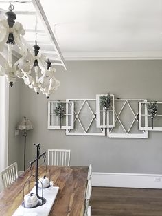 the dining room table is set with white chairs and chandelier hanging from the ceiling