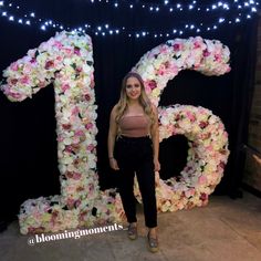 a woman standing in front of a floral number