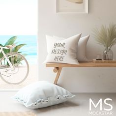 two pillows sitting on a shelf next to a bicycle and beach view window with the words your mesm here printed on it