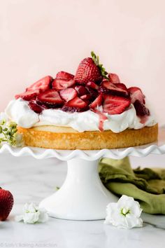 a strawberry shortcake with whipped cream and fresh strawberries on top, ready to be eaten