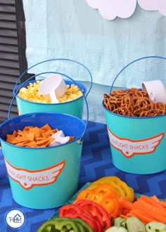 three buckets filled with different types of food on top of a blue table cloth