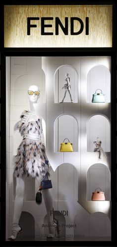 a display case with mannequins and handbags in it