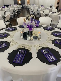 the table is set with purple and black place settings