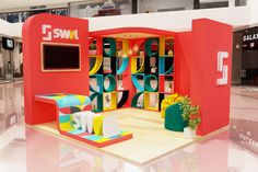 an exhibition booth designed to look like a store with colorful furniture and accessories on display