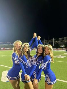 the cheerleaders are posing for a photo on the football field with their hands in the air