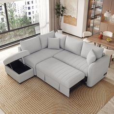 a living room with a large sectional couch and coffee table in front of the window