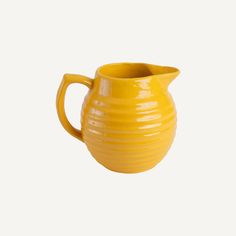 a yellow ceramic pitcher on a white background