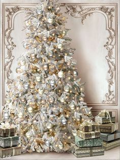 a white christmas tree with gold and silver ornaments