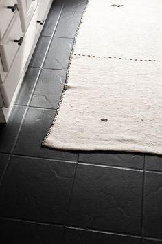 a black and white bathroom with a rug on the floor